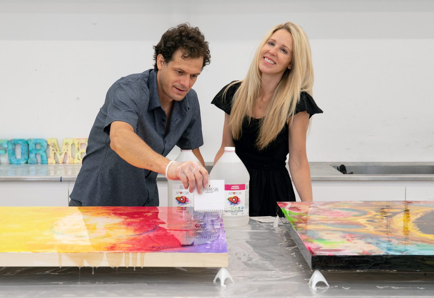 David Zak applying ArtResin to original artwork in the studio, alongside ArtResin resin and hardener